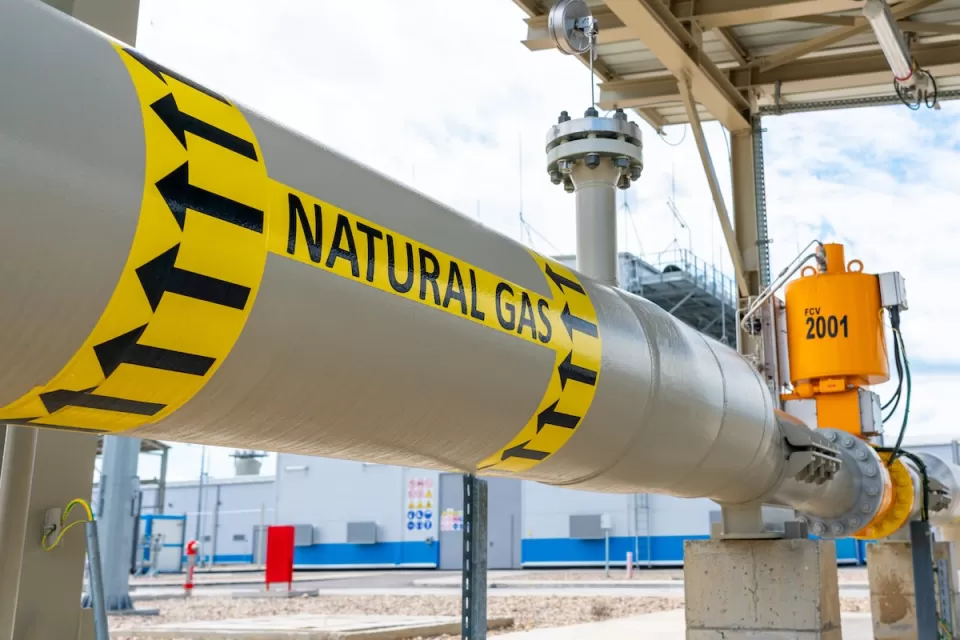 Close-up of pipe labeled with yellow and black Natural Gas sticker.